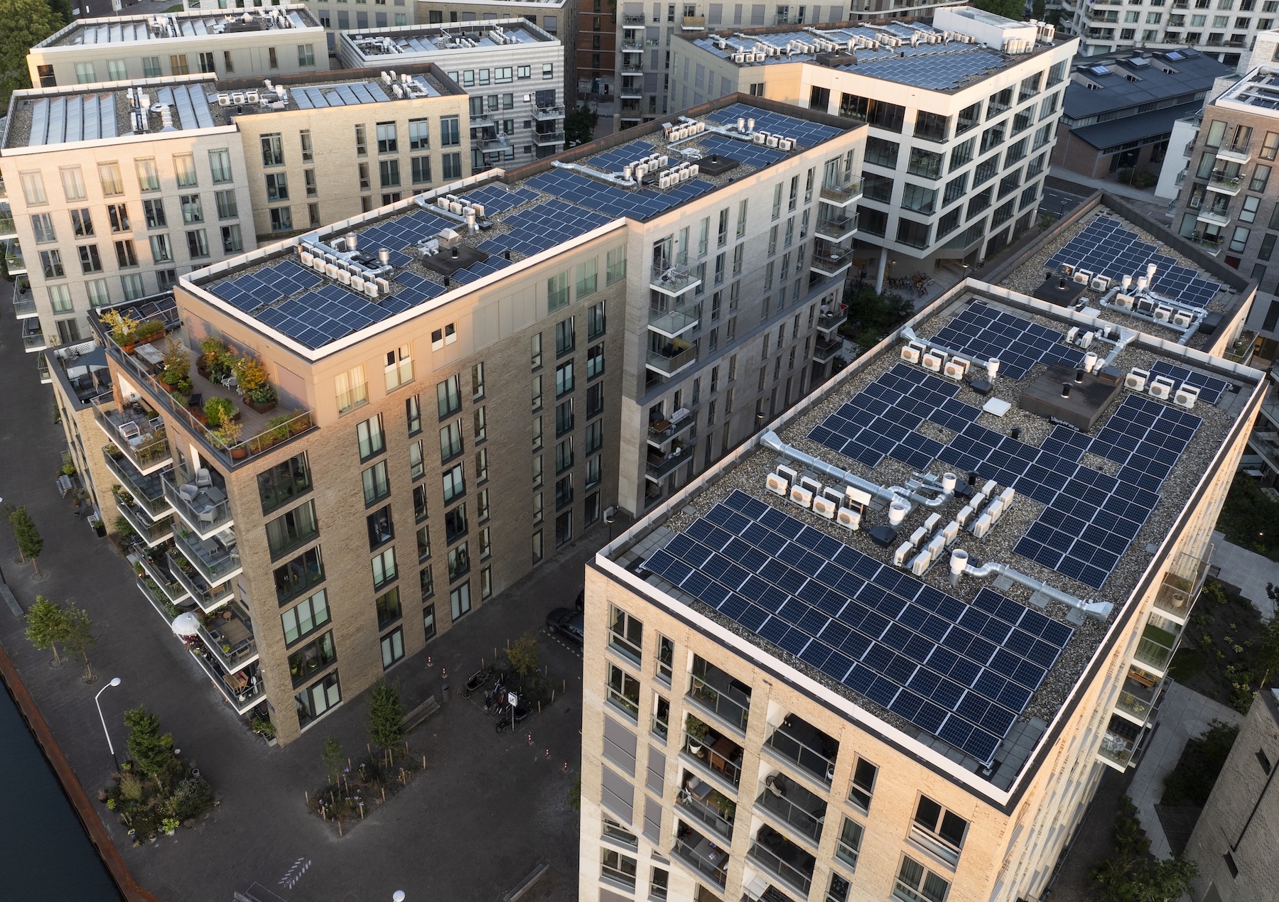 An elevated sunrise view of apartments, solar panels